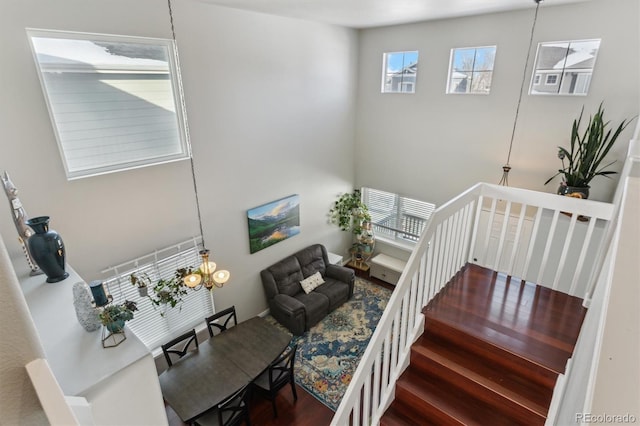 stairs with hardwood / wood-style floors and a chandelier