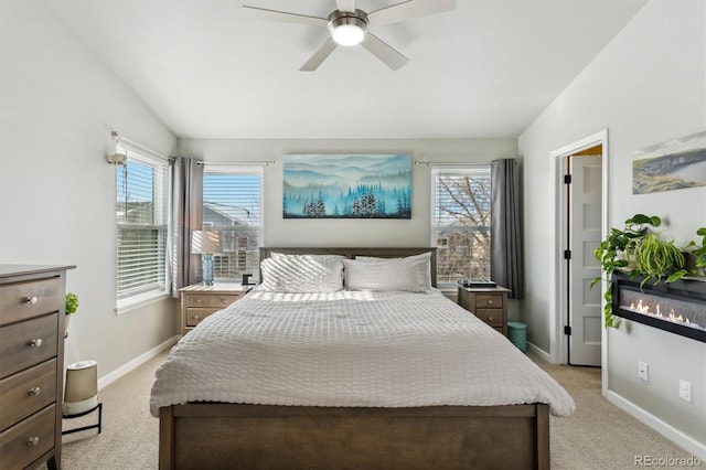 carpeted bedroom with ceiling fan, vaulted ceiling, and multiple windows