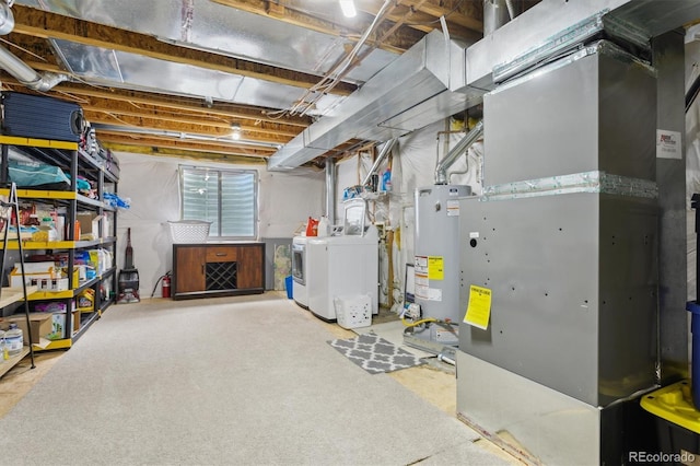 basement with heating unit, gas water heater, and independent washer and dryer