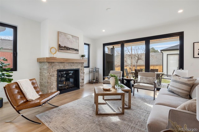 living room featuring a brick fireplace and light wood-type flooring