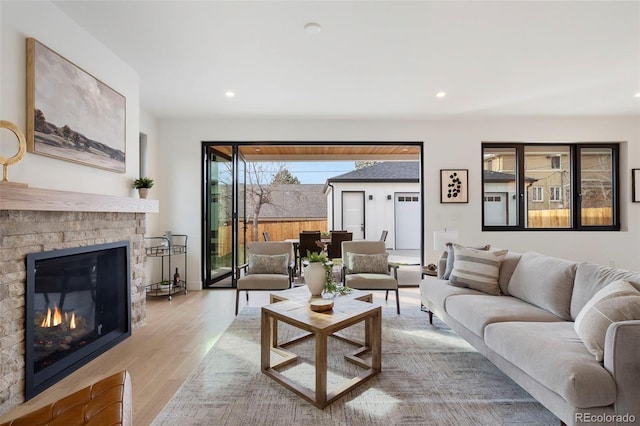 living room featuring a brick fireplace and light wood-type flooring