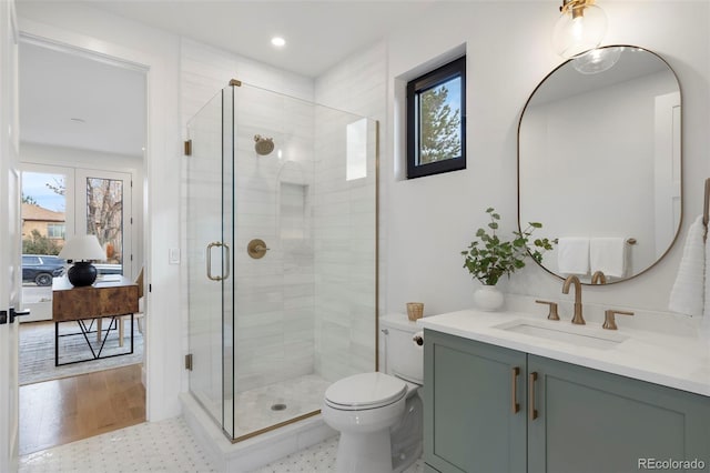 bathroom with vanity, an enclosed shower, and toilet