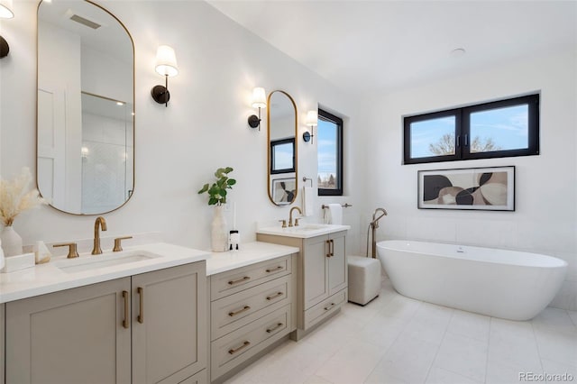 bathroom featuring vanity, tile patterned flooring, tile walls, and a bathing tub