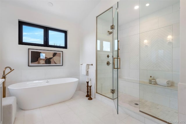 bathroom featuring tile patterned floors, shower with separate bathtub, and tile walls