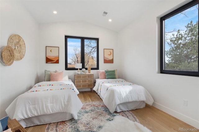 bedroom featuring lofted ceiling and light wood-type flooring