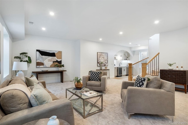 carpeted living room featuring sink and beverage cooler