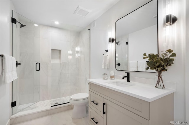 bathroom featuring vanity, toilet, and a shower with shower door