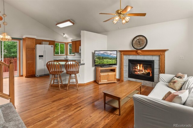 131 Morgan Ct, Loveland, CO 80537 - living room featuring a fireplace, a ceiling fan, light wood-type flooring, and high vaulted ceiling