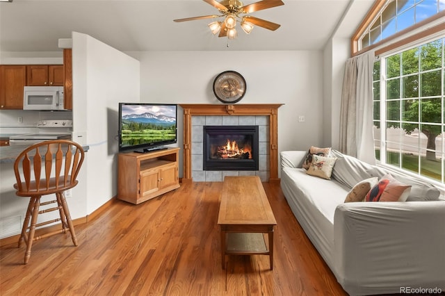 131 Morgan Ct, Loveland, CO 80537 - living room with a ceiling fan, a tile fireplace, and light wood-style floors
