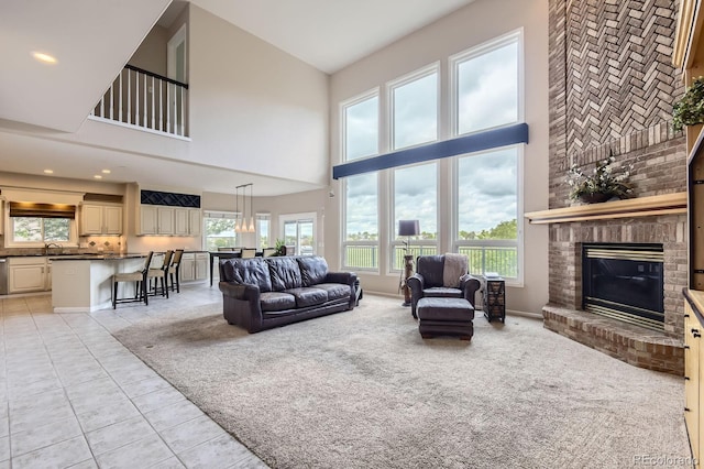 7758 Edgewater Ct, Lone Tree, CO 80124 - living room with a towering ceiling, a brick fireplace, light tile patterned floors, healthy amount of natural light, and light carpet