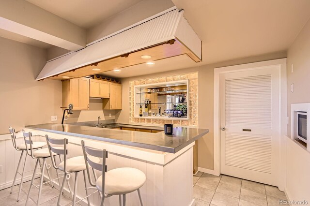 7758 Edgewater Ct, Lone Tree, CO 80124 - kitchen featuring a kitchen bar, a sink, light tile patterned floors, a peninsula, and recessed lighting