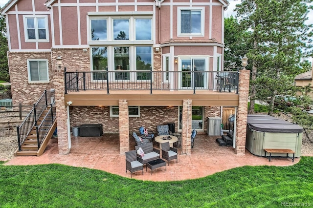 7758 Edgewater Ct, Lone Tree, CO 80124 - rear view of house featuring a hot tub, a patio, a fire pit, and a lawn