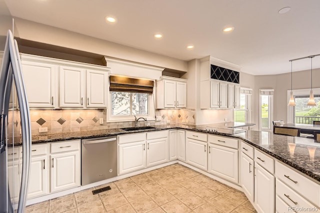 7758 Edgewater Ct, Lone Tree, CO 80124 - kitchen with stainless steel appliances, white cabinets, decorative backsplash, a sink, and decorative light fixtures