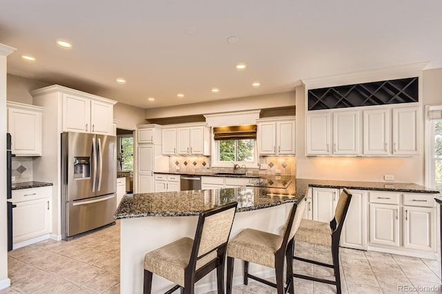 7758 Edgewater Ct, Lone Tree, CO 80124 - kitchen featuring stainless steel appliances, backsplash, white cabinets, a sink, and recessed lighting