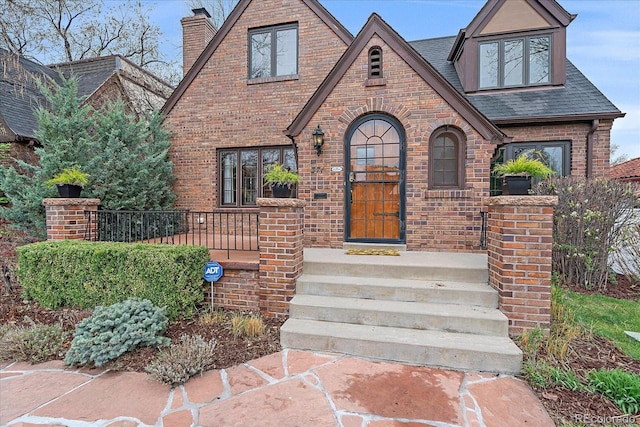 371 Birch St, Denver, CO 80220 - view of front of house with a chimney, brick siding, and roof with shingles