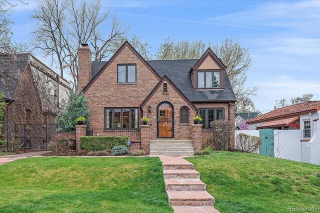 371 Birch St, Denver, CO 80220 - english style home featuring brick siding, roof with shingles, a front lawn, and fence