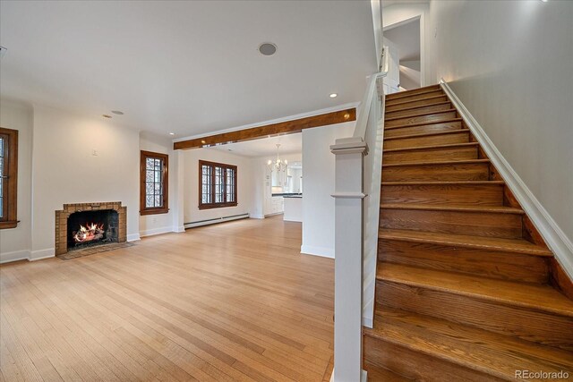 371 Birch St, Denver, CO 80220 - stairs featuring a baseboard radiator, wood finished floors, a fireplace, baseboards, and recessed lighting