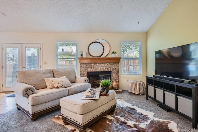 living room featuring a textured ceiling, vaulted ceiling, french doors, carpet flooring, and a brick fireplace