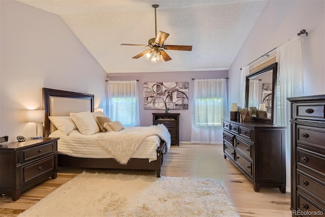 bedroom with ceiling fan, multiple windows, light hardwood / wood-style flooring, and vaulted ceiling