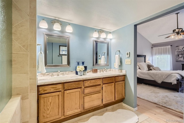 bathroom featuring vaulted ceiling, ceiling fan, hardwood / wood-style flooring, and vanity