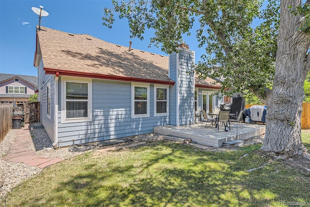 back of house with a deck and a yard