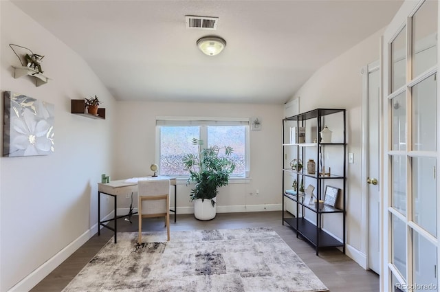 office space featuring baseboards, visible vents, and wood finished floors