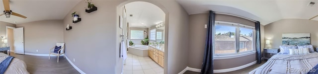 bathroom with a healthy amount of sunlight, baseboards, visible vents, and lofted ceiling