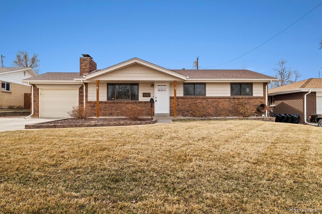ranch-style house with brick siding, concrete driveway, a front yard, a chimney, and a garage