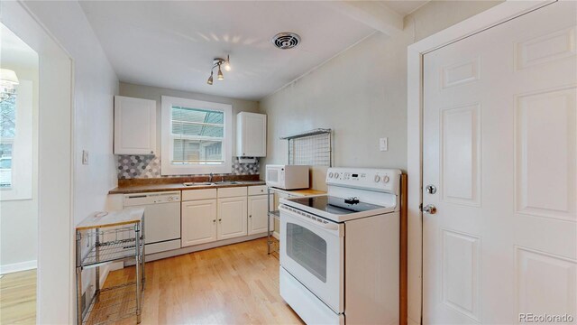 kitchen with backsplash, white appliances, visible vents, white cabinets, and light wood-style floors