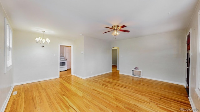 unfurnished room featuring ceiling fan with notable chandelier, baseboards, arched walkways, light wood-style floors, and visible vents