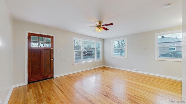 entryway with baseboards, light wood-style floors, and a ceiling fan