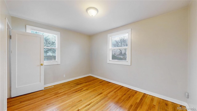 spare room featuring baseboards and light wood-style flooring