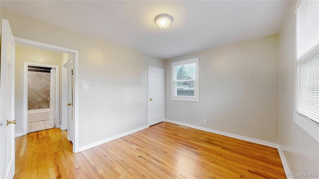 unfurnished bedroom featuring a closet, baseboards, and light wood-style floors