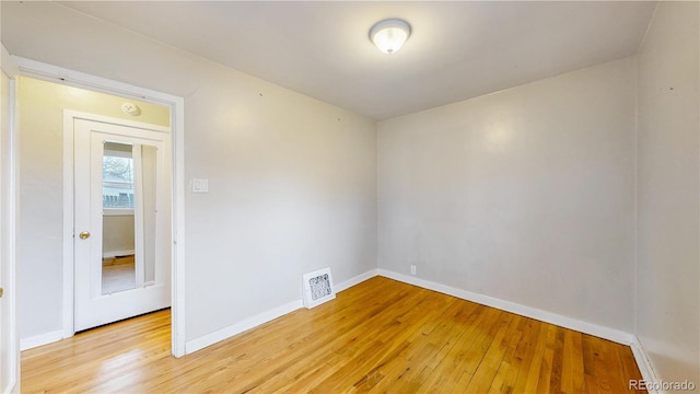 unfurnished room with baseboards, light wood-style flooring, and visible vents