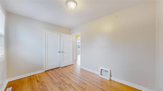 unfurnished room featuring baseboards, visible vents, and light wood-type flooring