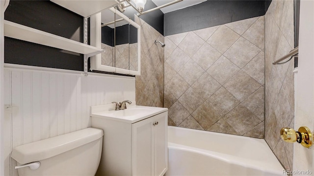 bathroom featuring shower / tub combination, toilet, vanity, and wainscoting