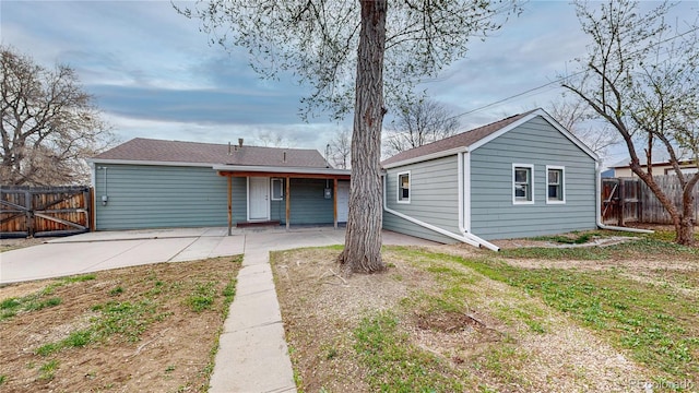 rear view of property with fence, a gate, and a patio area