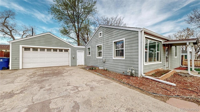 view of home's exterior with a detached garage, fence, and an outbuilding