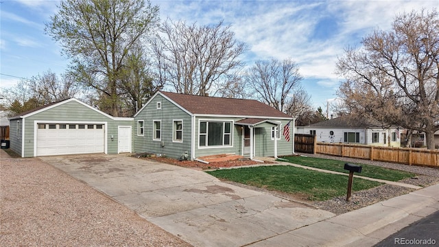 view of front of property with a front yard, a garage, and fence