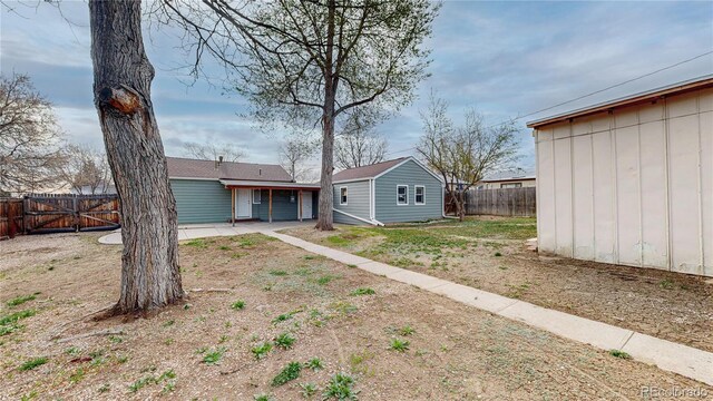 exterior space featuring a gate, fence, and a patio