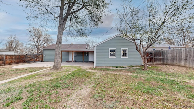 back of house with a fenced backyard, a lawn, a gate, and a patio area
