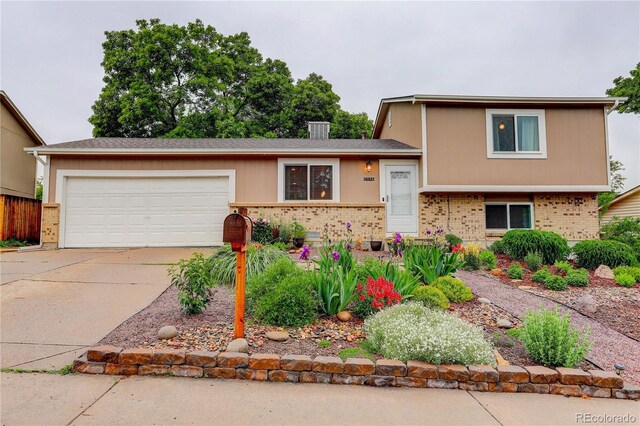10527 Pierson Cir, Westminster, CO 80021 - tri-level home featuring brick siding, an attached garage, and concrete driveway