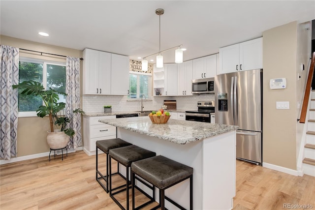 10527 Pierson Cir, Westminster, CO 80021 - kitchen featuring appliances with stainless steel finishes, baseboards, light wood-style flooring, white cabinets, and recessed lighting
