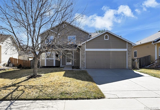 traditional-style house featuring fence, driveway, an attached garage, a front lawn, and brick siding