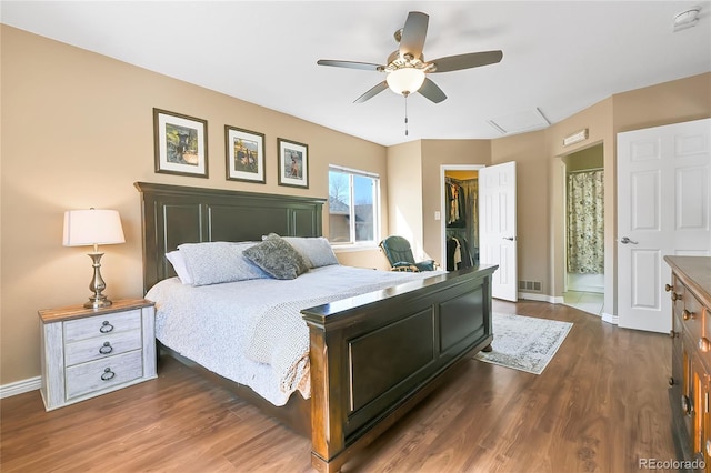 bedroom featuring dark wood finished floors, a spacious closet, baseboards, and a closet