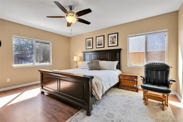 bedroom featuring wood finished floors, baseboards, and ceiling fan