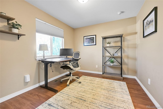 office space with dark wood finished floors and baseboards