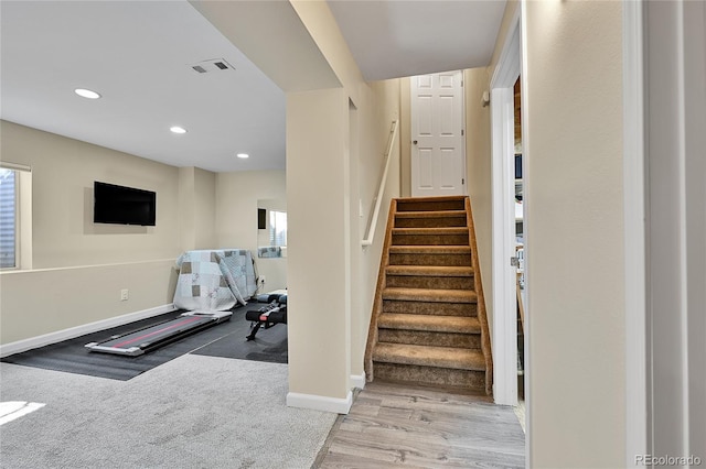 staircase featuring recessed lighting, visible vents, baseboards, and wood finished floors