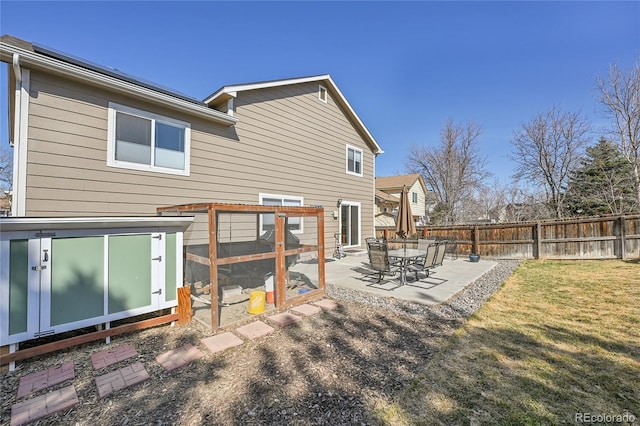 rear view of property featuring a patio area, fence, and a lawn