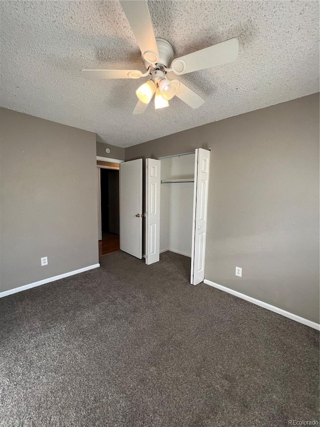 unfurnished bedroom with ceiling fan, dark carpet, a textured ceiling, and a closet